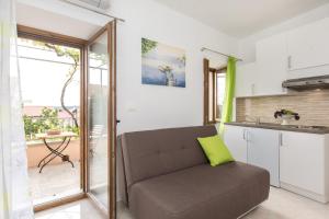 a living room with a couch and a kitchen at Apartments Gabi in Punat