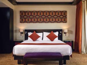 una camera da letto con un grande letto con cuscini rossi di Mövenpick Resort Aswan a Aswan