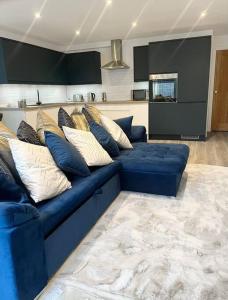niebieską kanapę z poduszkami w salonie w obiekcie Luxury 3 Bedroom House w mieście Worthing