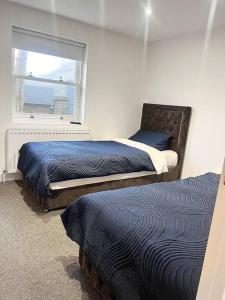 a bedroom with two beds and a window at Luxury 3 Bedroom House in Worthing