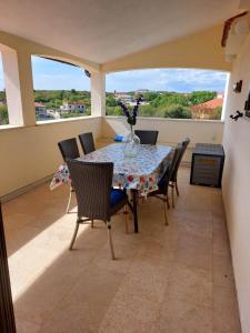 een eetkamer met een tafel en stoelen op een balkon bij Apartmani Tara Medulin in Medulin