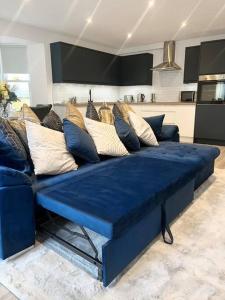 un sofá azul con almohadas en la sala de estar en Luxury 3 Bedroom House, en Worthing