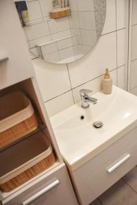 een badkamer met een wastafel en een spiegel bij Főtér Apartman in Kiskunhalas