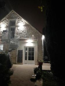una casa con luci sul lato di essa di notte di Chambre d'hôtes SOPHORA - Les Clés des Lys a Moret-sur-Loing