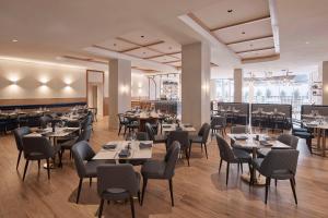 Hotel Alba Adelaide في أديلايد: مطعم فيه طاولات وكراسي في الغرفة