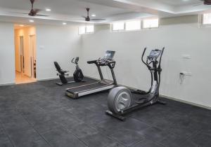 einen Fitnessraum mit drei Heimtrainern in einem Raum in der Unterkunft The Healing Hills Naturopathy and Wellness Center in Coimbatore