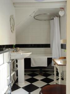 ein Badezimmer mit einem Waschbecken und einer Badewanne in der Unterkunft Badger Cottage at Alde Garden in Saxmundham