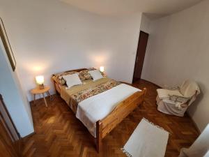 a bedroom with a large bed and a chair at Apartmani Tara Medulin in Medulin