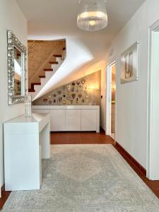 a living room with a staircase and a white kitchen at B&B Lavi Ortisei val Gardena in Ortisei