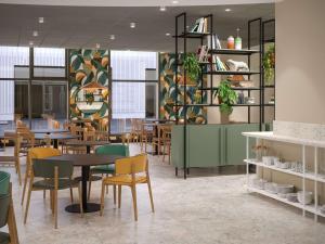 a dining room with tables and chairs and plants at greet Hotel Paris 13 Porte d'Italie in Le Kremlin-Bicêtre