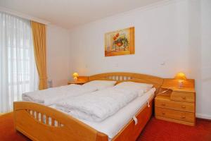 um quarto com uma cama de madeira e uma cómoda de madeira em Residenz Bismarck, Whg 11 em Westerland