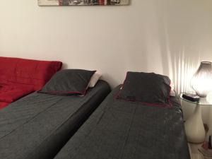 カンヌにあるAppartement Palais des Festivalsのベッドルーム1室(ベッド2台、赤いソファ付)