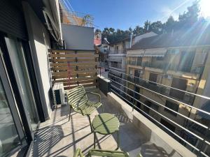 d'un balcon avec deux chaises vertes et une fenêtre. dans l'établissement Skyline Oasis thesbnb, à Thessalonique