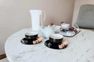 un tavolo con due tazze e un set per la preparazione del tè sopra di Cabarfeidh Hotel a Stornoway