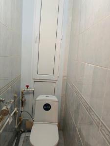 een badkamer met een wit toilet en een witte muur bij Центр Гостеприимства in Aqtöbe