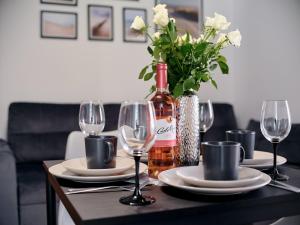 a table with plates and glasses and a bottle of wine at Villa Łeba II - Loft Apartments in Łeba