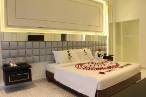 a bedroom with a bed with a flower arrangement on it at Hengly Mohasambath Hotel & Spa in Phumĭ Kruŏs