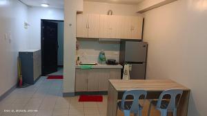 a kitchen with a table and chairs and a refrigerator at Tranquil Cool Studio Condo Mactan Cebu in Lapu Lapu City
