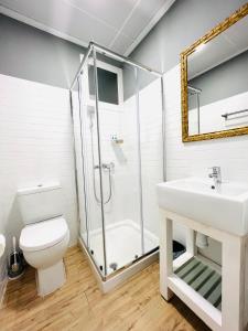a bathroom with a shower and a toilet and a sink at Suites Puente de Hierro in Benicàssim