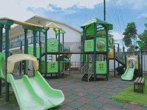 a playground with green equipment and slides in a yard at Tranquil Cool Studio Condo Mactan Cebu in Lapu Lapu City