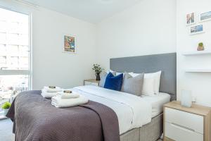倫敦的住宿－Modern New 2BR flat wBalcony in peaceful Brixton，一间卧室配有一张大床,桌子上配有毛巾