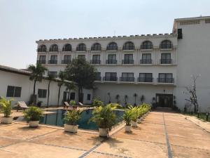 a building with a swimming pool in front of it at Hengly Mohasambath Hotel & Spa in Phumĭ Kruŏs