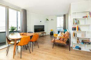 倫敦的住宿－Modern New 2BR flat wBalcony in peaceful Brixton，客厅配有桌椅和电视。
