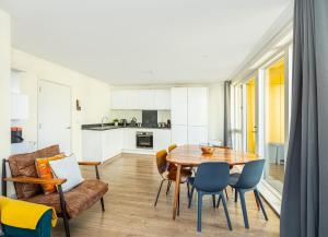 倫敦的住宿－Modern New 2BR flat wBalcony in peaceful Brixton，厨房以及带桌椅的用餐室。