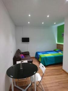 Cette chambre comprend une table, un lit, une table et des chaises. dans l'établissement Apartamentos EconoStay Barbieri 1, à Madrid
