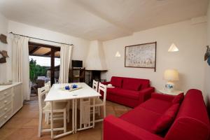 uma sala de estar com um sofá vermelho e uma mesa em Casa Isidora by Wonderful Italy em Arzachena