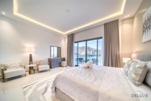a bedroom with a large bed and a large window at Grand 4BR Villa with Assistant's and Driver's Room Al Dana Island Fujairah by Deluxe Holiday Homes in Fujairah
