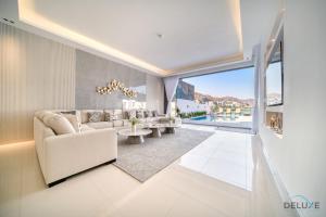 un soggiorno con divano e tavolo di Grand 4BR Villa with Assistant's and Driver's Room Al Dana Island Fujairah by Deluxe Holiday Homes a Fujaira