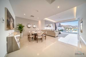 a dining room with a table and a couch at Grand 4BR Villa with Assistant's and Driver's Room Al Dana Island Fujairah by Deluxe Holiday Homes in Fujairah