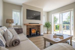 a living room with a couch and a fireplace at Larks Rise in Burnham Market