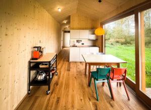 uma cozinha e sala de jantar de uma pequena casa em Die Klingerei - Tiny House Wiese em Pettighofen