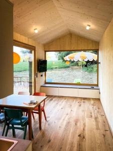 een woonkamer met een tafel en een groot raam bij Die Klingerei - Tiny House Wiese in Pettighofen