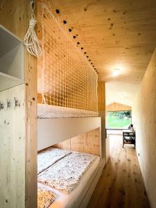 um quarto com 2 beliches e uma rede em Die Klingerei - Tiny House Wiese em Pettighofen