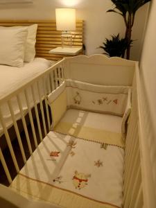 - un lit bébé avec un siège dans une chambre dans l'établissement Casita de Invitados con entrada privada, piscina y aire acondicionado, à Valdemorillo