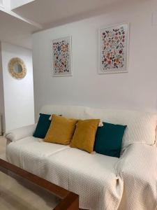 a white couch in a room with two pictures on the wall at Piso en Gandía in Gandía