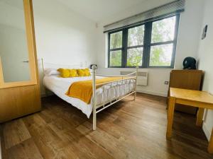 a bedroom with a bed with yellow pillows on it at Comfy Canal View Apartment in Coventry