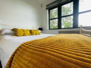 a bedroom with a large yellow blanket on a bed at Comfy Canal View Apartment in Coventry