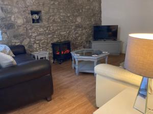 a living room with a couch and a fireplace at Beautiful 3-Bed Cottage in Llancarfan Nr Cardiff in Barry