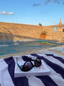 a pair of glasses sitting on a book next to a swimming pool at Hotel Everest in Córdoba