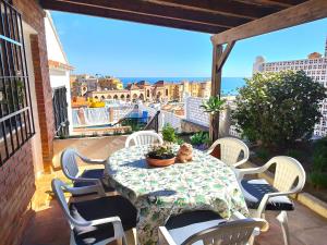 una mesa y sillas en un balcón con vistas al océano en Villa Las Mercedes - Urbanización El Castillo en Fuengirola