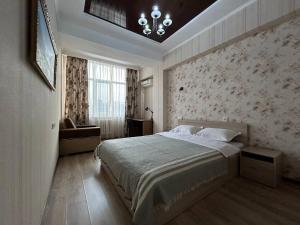 AURA on Ryskulov street 30 في بيشكيك: غرفة نوم بسرير كبير وثريا