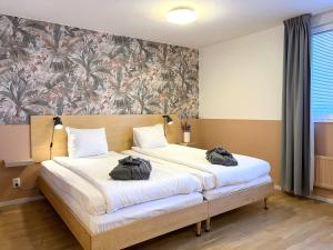 Un dormitorio con una cama con dos bolsas. en 2Home Hotel Apartments en Solna