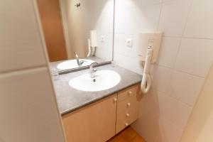 a bathroom with two sinks and a mirror at Azureva Métabief in Métabief