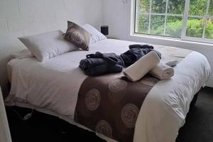 uma cama grande com cobertores e almofadas em Orchard 2 Bedroom Apartment in Devonport 