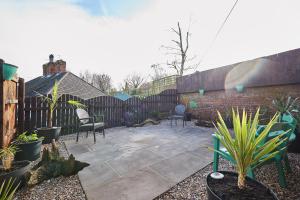 a patio with chairs and plants in a backyard at Host & Stay - Gas Light Cottage in Ripon