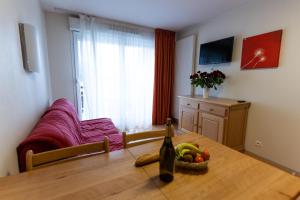 a table with a bottle of wine and a bowl of fruit at Azureva Métabief in Métabief